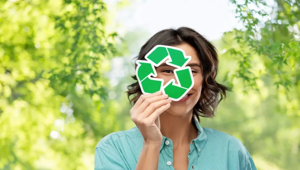 mulher segurando o símbolo da reciclagem