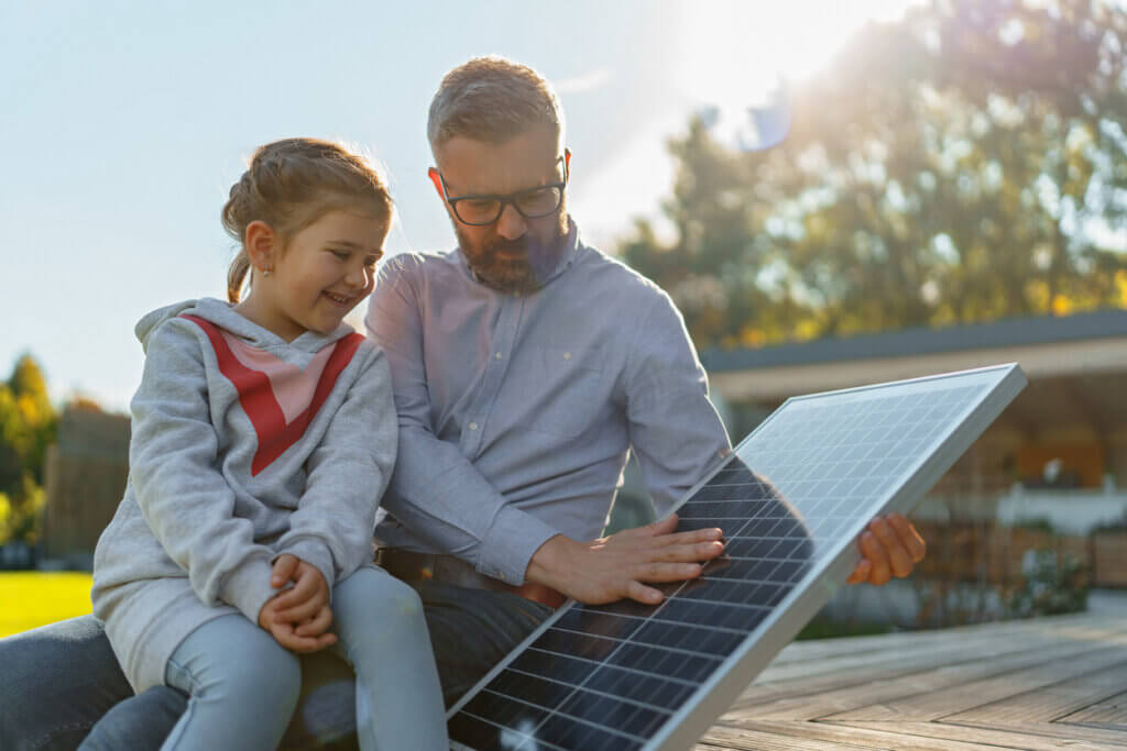 pai mostrando placa de energia solar para filha