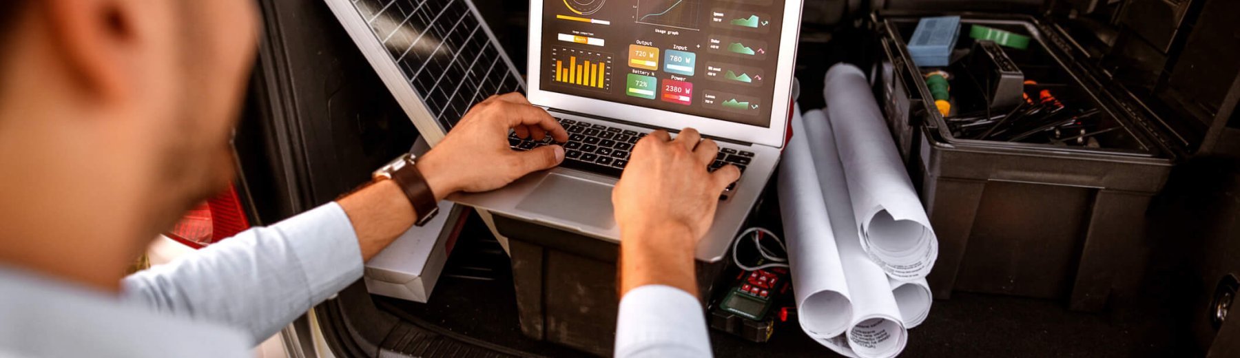 homem mexendo no notebook em um sistema de energia renovável para representar sistema fotovoltaico