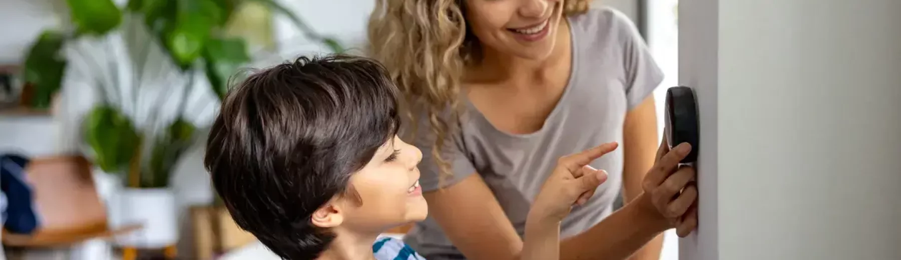 Mãe e filho juntos mexendo em uma configuração da sua casa