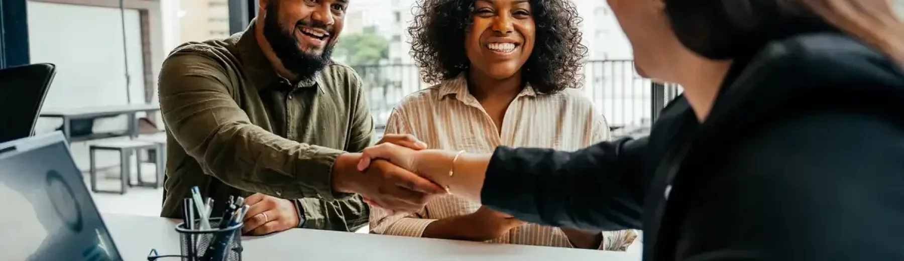 Reunião de negócios com pessoas sorridentes e profissionais treinando um aperto de mão em ambiente de escritório moderno para otimização de SEO em relação a trabalho em equipe e negócios.